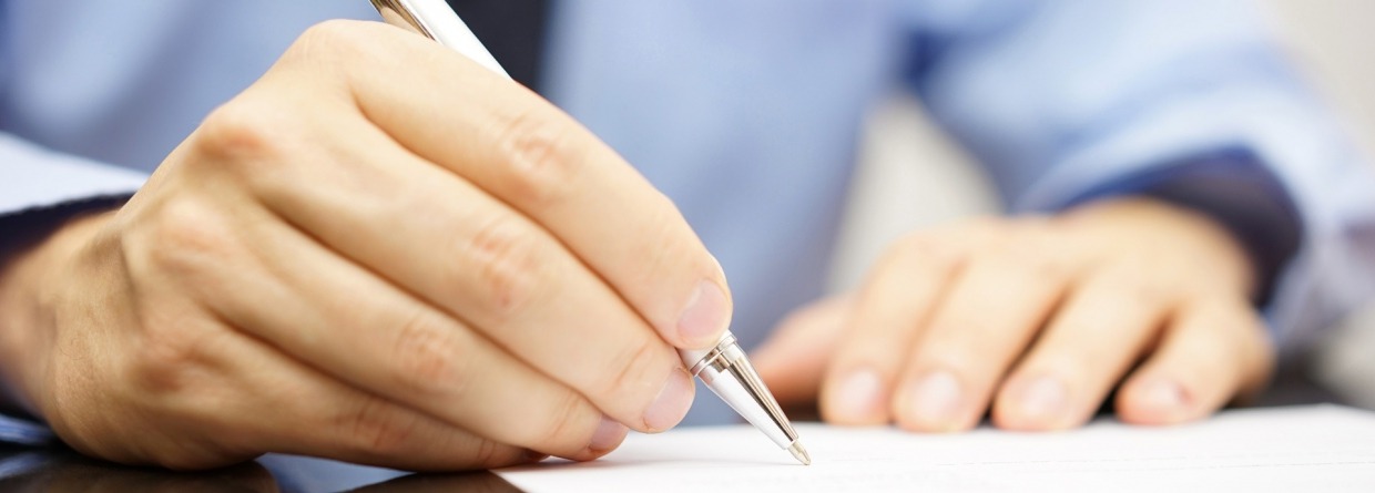 man ondertekent een document