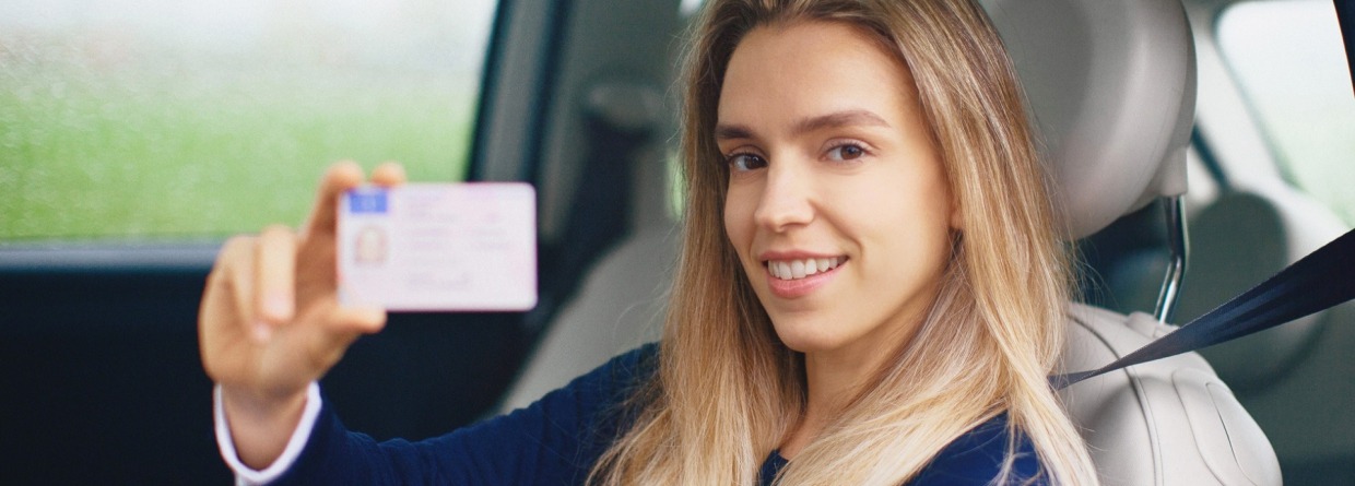vrouw laat rijbewijs zien terwijl ze in de auto zit